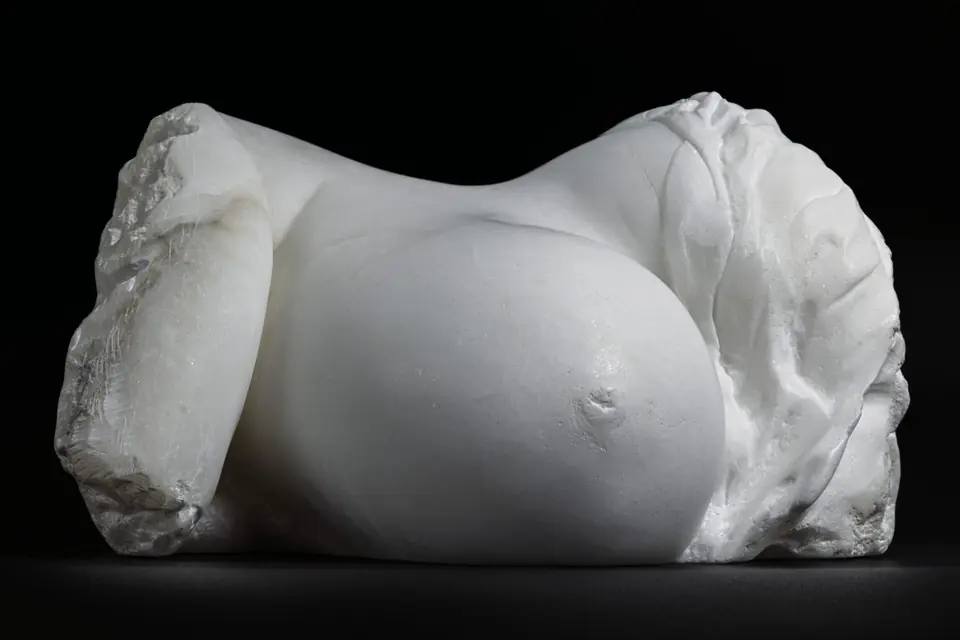 Torso de mujer embarazada tallado en alabastro blanco sobre fondo negro