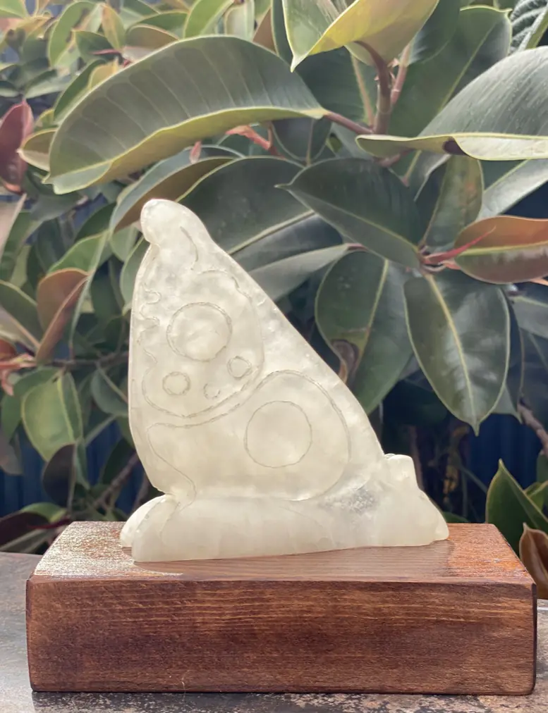 Escultura de mariposa tallada en alabastro sobre peana de madera