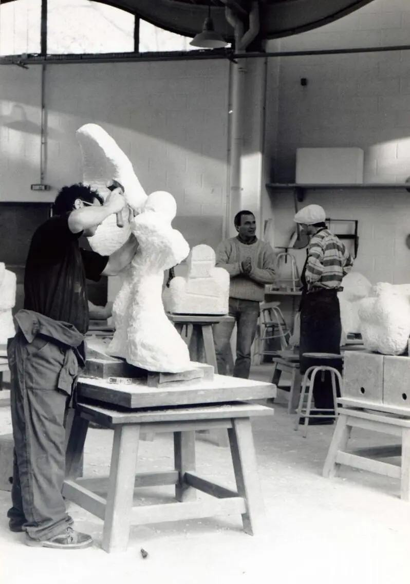 Fotografía en blanco y negro de Marcos Domínguez tallando una escultura en París en 1996